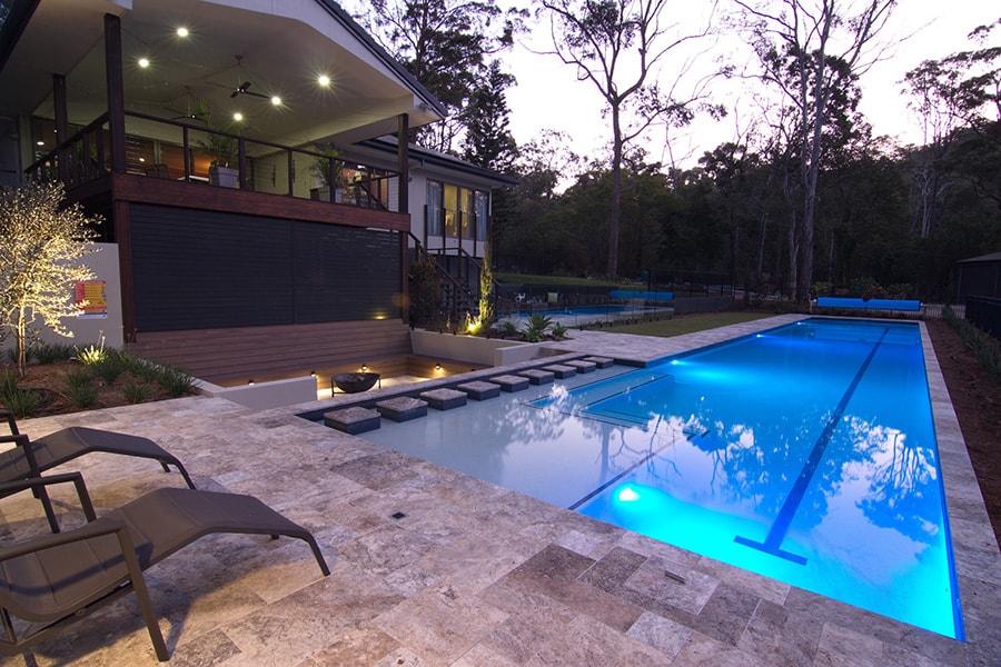 Lap pool with blue lights and surrounding landscape