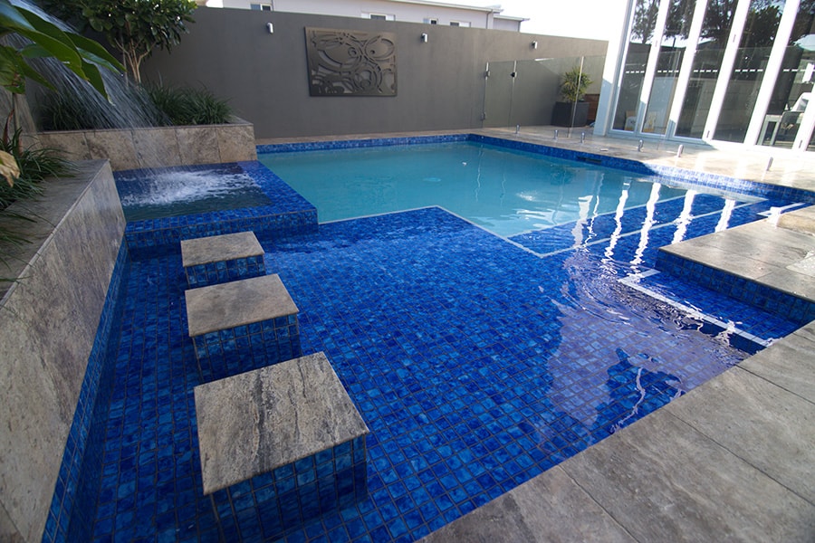 In ground pool with steps and water feature